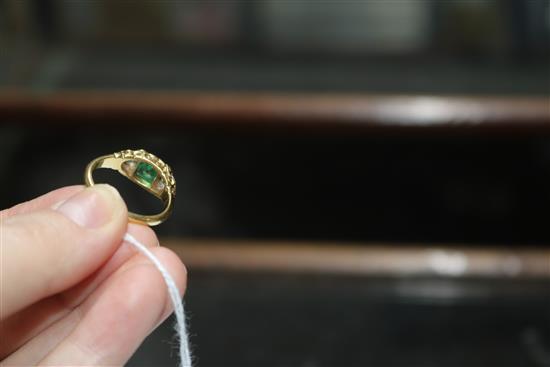 A late Victorian yellow metal, emerald and diamond three stone ring, size Q.